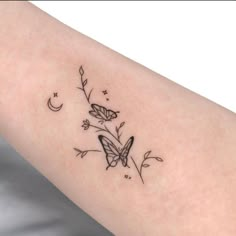 a woman's arm with two butterflies on it and the moon in the background