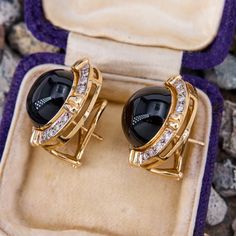 These vintage earrings are each centered with one (1) round onyx cabochon in a removable bezel setting. The frame of the earrings are each bead set with sixteen (16) round brilliant cut diamonds. The earrings measure 23.0mm wide by 10.3mm deep, finished with posts and omega backs for pierced ears. Luxury Gold Diamond Cabochons, Luxury Diamond Cabochons For Formal Occasions, Formal Hallmarked Diamond Cabochons, Classic Yellow Gold Cabochons For Formal Occasions, Fine Jewelry Yellow Gold Cabochons For Formal Occasions, Luxury Cabochons With Bezel Setting, Luxury Round Cabochons With Bezel Setting, Classic Round Hallmarked Cabochons, Luxury Cabochon Jewelry For Formal Occasions