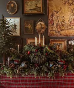 a christmas mantle with candles and pictures on the wall