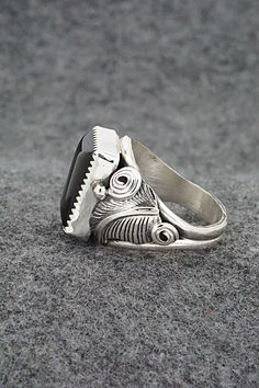 This onyx and sterling silver ring was made by Navajo silversmith Darrell Morgan. The inside is signed DM and stamped sterling.Size: 11.5Length: 3/4"Width: 1/2"Free shipping on all orders! We ship with USPS and always include tracking. All orders ship within a day of payment.Returns are accepted up to 30 days after you receive your order. Just send us a message. Our shop offers cash back or store credit. The item must be returned in new condition. Unique Black Sterling Silver Engraved Ring, Unique Handmade Black Engraved Ring, Black Artisan Jewelry With Polished Finish, Artisan Black Jewelry With Polished Finish, Artisan Black Sterling Silver Rings, Southwestern Black Sterling Silver Jewelry, Handmade Adjustable Black Engraved Ring, Adjustable Black Handmade Engraved Ring, Sterling Silver Ring