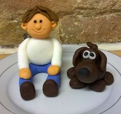 there is a cake with a boy and dog on the plate next to each other