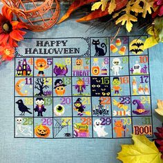 a cross - stitch halloween calendar with pumpkins, bats and other decorations on it