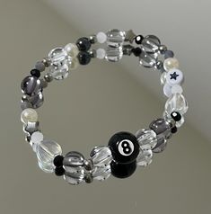 A bracelet crafted with alternating black and clear beads, strung together on a stretchy cord for a flexible and comfortable fit. The contrast between the black and clear beads creates a sleek and stylish look. MEASUREMENT: 16 centimeters (6.2 inches) IMPORTANT NOTE: - Avoid wearing the bracelet while swimming or showering to prevent water damage and weakening of the elastic. - Be gentle when putting on or taking off the bracelet to avoid overstretching the elastic. 8 Ball Bracelet, Trendy Adjustable Black Crystal Bracelet, Trendy Black Beaded Bracelets With Letter Beads, Casual Black Stretch Bracelet With Letter Beads, Black Beaded Bracelets With Letter Beads, Black Round Bracelets With Letter Beads, Black Stretch Bracelet With Letter Beads, Black Stretch Bracelet With Letter Beads And Round Beads, Trendy Black Bracelets With Letter Beads