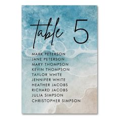 a table number card with the names of five different people in blue watercolors