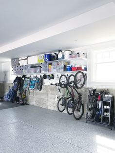 there is a bike hanging on the wall next to it's storage bins