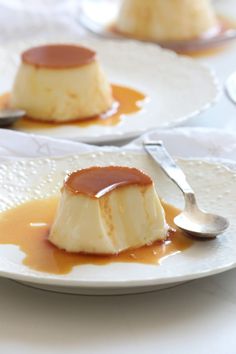 two white plates topped with cheesecake covered in caramel sauce next to each other