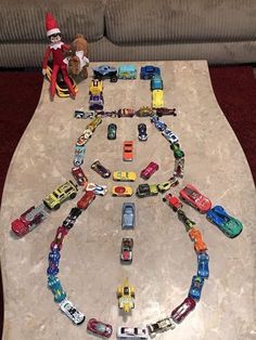 toy cars are arranged in the shape of a circle on a table with elf's hat