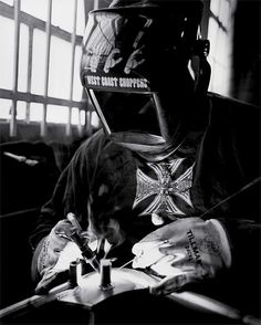 black and white photograph of a man wearing a gas mask writing on a piece of paper