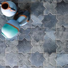 an aerial view of a teapot and cup on a tile floor with hexagonal tiles