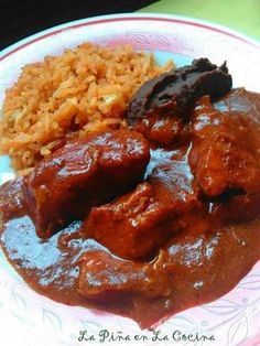 a plate with rice, meat and other food items on top of it in red sauce