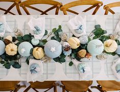 the table is decorated with pumpkins and greenery