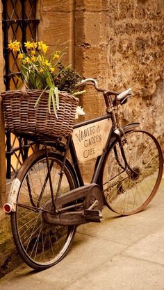 an old bicycle with a basket full of flowers