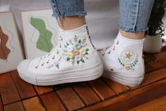 "Experience the art of hand embroidery on Converse embroidered shoes, a testament to meticulous craftsmanship."            Custom wedding converse platform/ Embroidered converse high tops chuck taylor 1970s/ Personalized bridal sneakers/ Custom wedding shoes bride  💸 Price includes Converse Shoes and floral embroidery as shown 🌸 You can send me your Converse/Vans shoes or I can buy them for you. We stock all the Converse and Vans shoes you want, if you want other Converse/Vans shoes in the sto Spring Wedding High-top Sneakers, Converse Plateau, Embroidery On Converse, Embroidered Converse High Tops, Custom Wedding Shoes, Bridal Sneakers, Embroidered Converse, High Top Chucks, Converse Platform