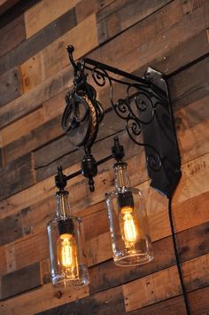 three light fixtures hanging from a wooden wall