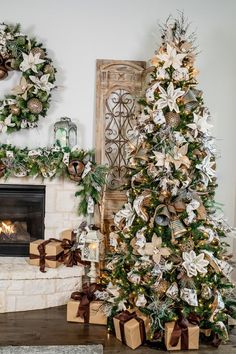 two christmas trees decorated with gold and silver ribbons in front of a fireplace mantel