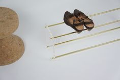 a pair of brown shoes sitting on top of a metal rack next to two rocks