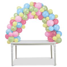 a white bench with balloons on it and a table in the foreground that has an arch