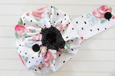 a white headband with black polka dots and flowers