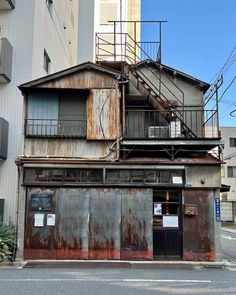 an old building with rusted metal doors and stairs