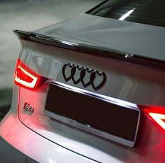 the rear end of an audi car with its lights on