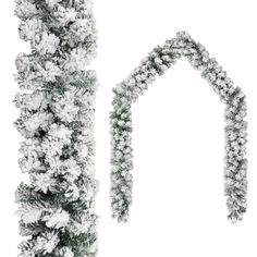 a white christmas tree with snow on it and an arch made out of pine cones