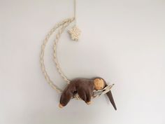 a stuffed animal hanging from a rope on the wall next to a small toy mouse