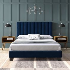 a bed with blue upholstered headboard and two nightstands next to it