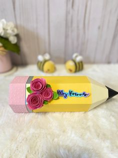 a pink and yellow pencil with flowers on it