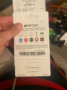 someone is holding up a gift card with the apple logo on it and barcodes