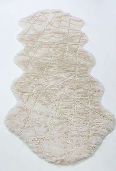 a white area rug with gold lines on the top and bottom, against a white background