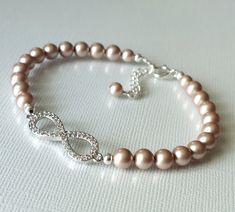 Wedding Champagne Powder Almond Pearl Infinity CZ Silver Bridal Bracelet. PLEASE READ ITEM DESCRIPTION and SHOP POLICIES before placing your order, and contact me with any questions! BRACELET is about 7.36 inches (18.7cm) long plus 1 inch extender chain. BRIDAL EARRINGS SECTION: https://www.etsy.com/shop/LanaChayka?ref=seller-platform-mcnav§ion_id=11638940 BRIDAL JEWELRY SETS SECTION: https://www.etsy.com/shop/LanaChayka?ref=seller-platform-mcnav§ion_id=25839214 BRIDAL NECKLACES SECTION: https://www.etsy.com/shop/LanaChayka?ref=seller-platform-mcnav§ion_id=11638944 Classy and elegant, this beautiful bracelet is perfect for weddings or special occasions such as birthdays, anniversaries, graduations, proms...or whatever you can imagine! Handmade bracelet, is made with Powder Almond Champagne Elegant Infinity Bracelets For Wedding, Elegant Wedding Infinity Bracelets, Almond Champagne, Bridal Necklaces, Infinity Wedding, Wedding Champagne, Pearl Bridal, Champagne Wedding, Wedding Jewelry Bracelets