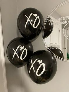 three black balloons with white numbers and the word xo written on them are in front of a cd