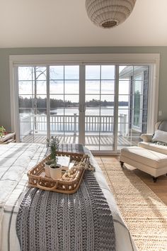 a bedroom with a large bed and sliding glass doors leading to a deck area that overlooks the water