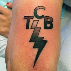 a person with a tattoo on their arm that says c, t, b and e