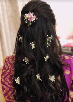 the back of a woman's head with flowers in her hair and other accessories