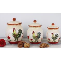 three ceramic jars with rooster designs and cookies