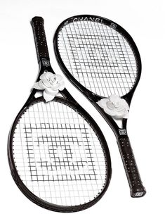 two tennis racquets with white flowers on them