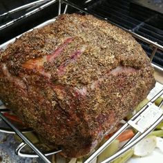 there is a large roasting meat on the grill with vegetables in front of it