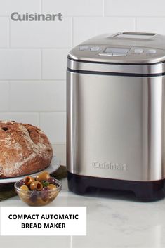 a loaf of bread sitting on top of a counter next to an automatic bread maker