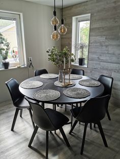 a dining room table with black chairs around it