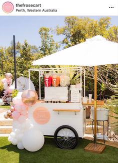 an ice cream cart is decorated with balloons