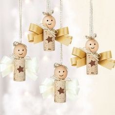 three wooden angel ornaments hanging from chains on a white background with gold stars and bows