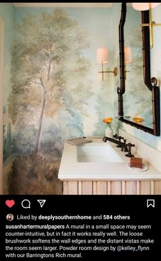 a bathroom with a painting on the wall next to a white sink and large mirror