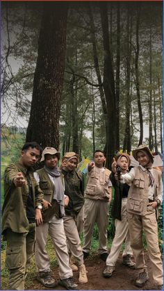 a group of people standing next to each other in the woods