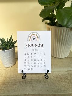 a calendar sitting on top of a table next to a potted plant