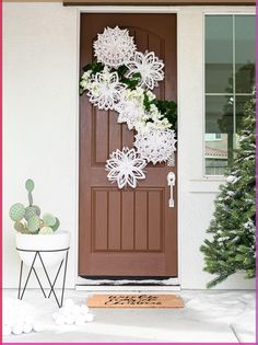 a door decorated with snowflakes and flowers next to a potted cacti