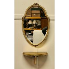 a mirror sitting on top of a wooden shelf next to a wall mounted shelf filled with books