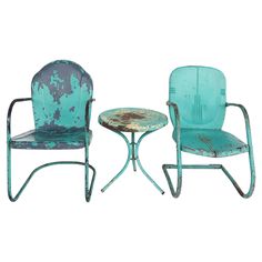 two chairs and a table made out of metal with rusted paint on the back