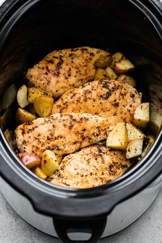 chicken and potatoes in the crock pot ready to be cooked with seasonings on top