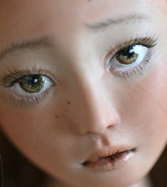 a close up photo of a doll with blue eyes